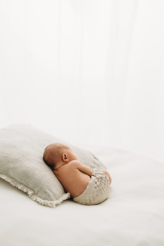 Picture of a Newborn baby who is 6 days old sleeping on a pillow in Kelowna B.C. photography studio