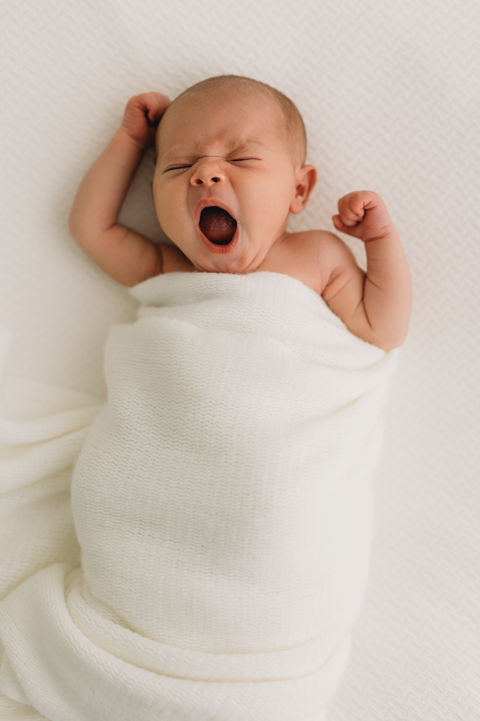 Newborn baby picture in Kelowna B.C. with baby yawning in a white blanket