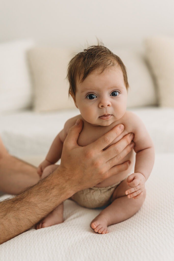 Picture of a Newborn baby who is 10 weeks old looking at the camera in Kelowna B.C. while sitting up