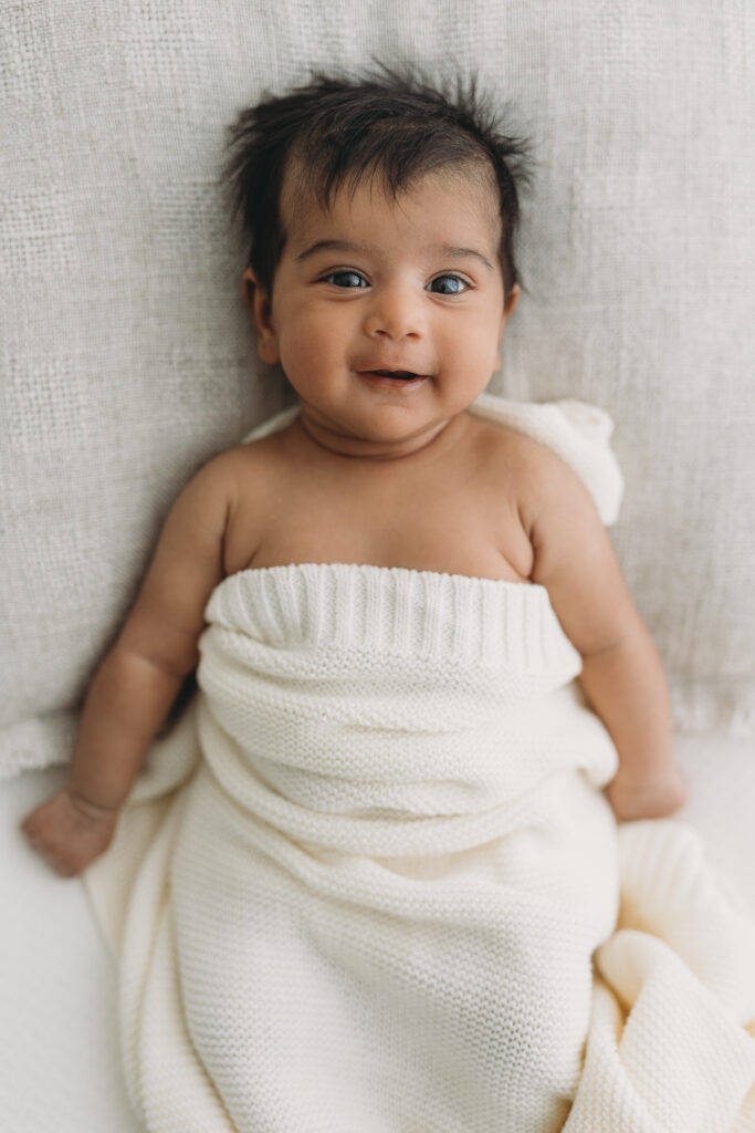 Picture of a Newborn baby who is 6 weeks old smiling at the camera in Kelowna B.C.